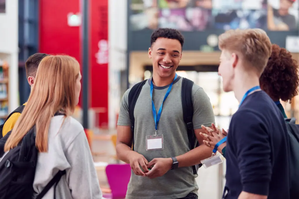 A group of college students meeting up and talking in a communal area