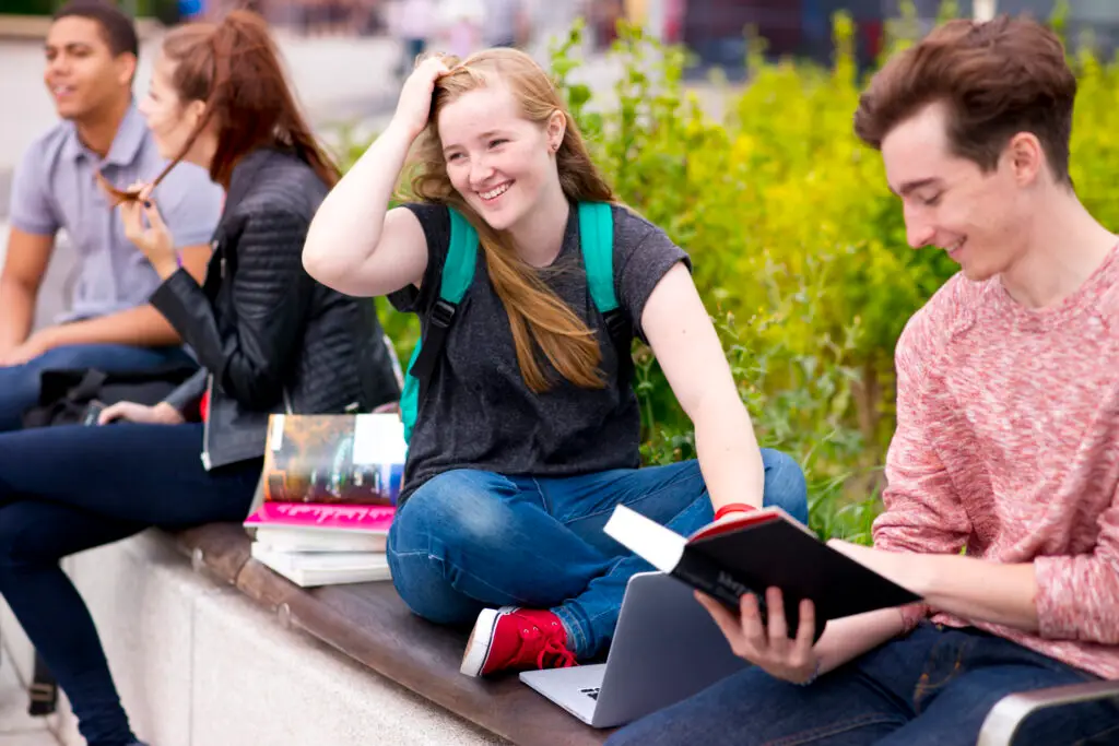 A group of students working together on an outside bench