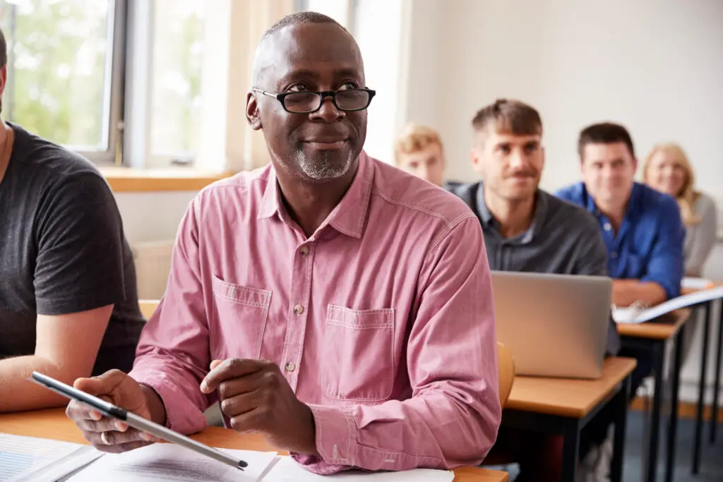 A mature student using a tablet in an adult education class