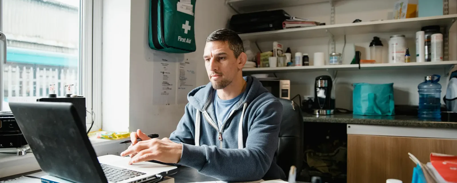 Mid-adult man is working on a laptop in his office.