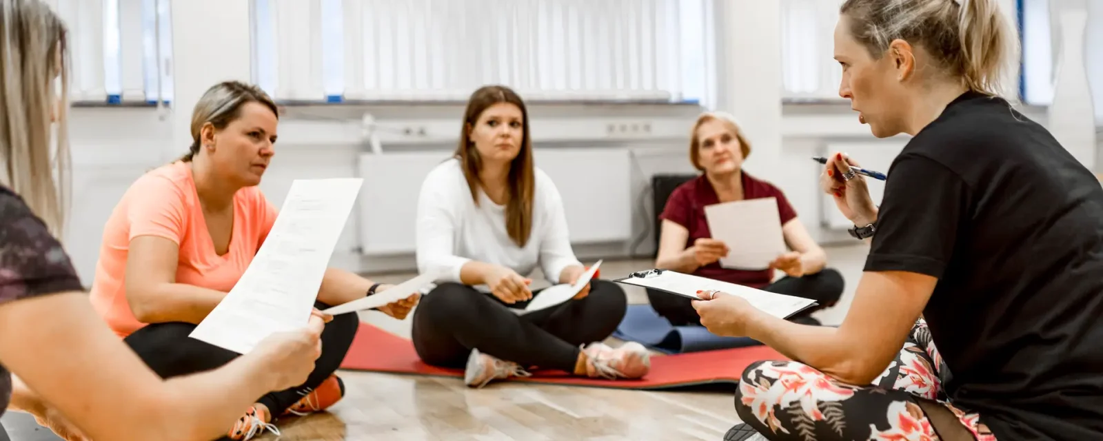Women talking about healthy life A group of women sat on yoga mats discussing healthy lifestyles
