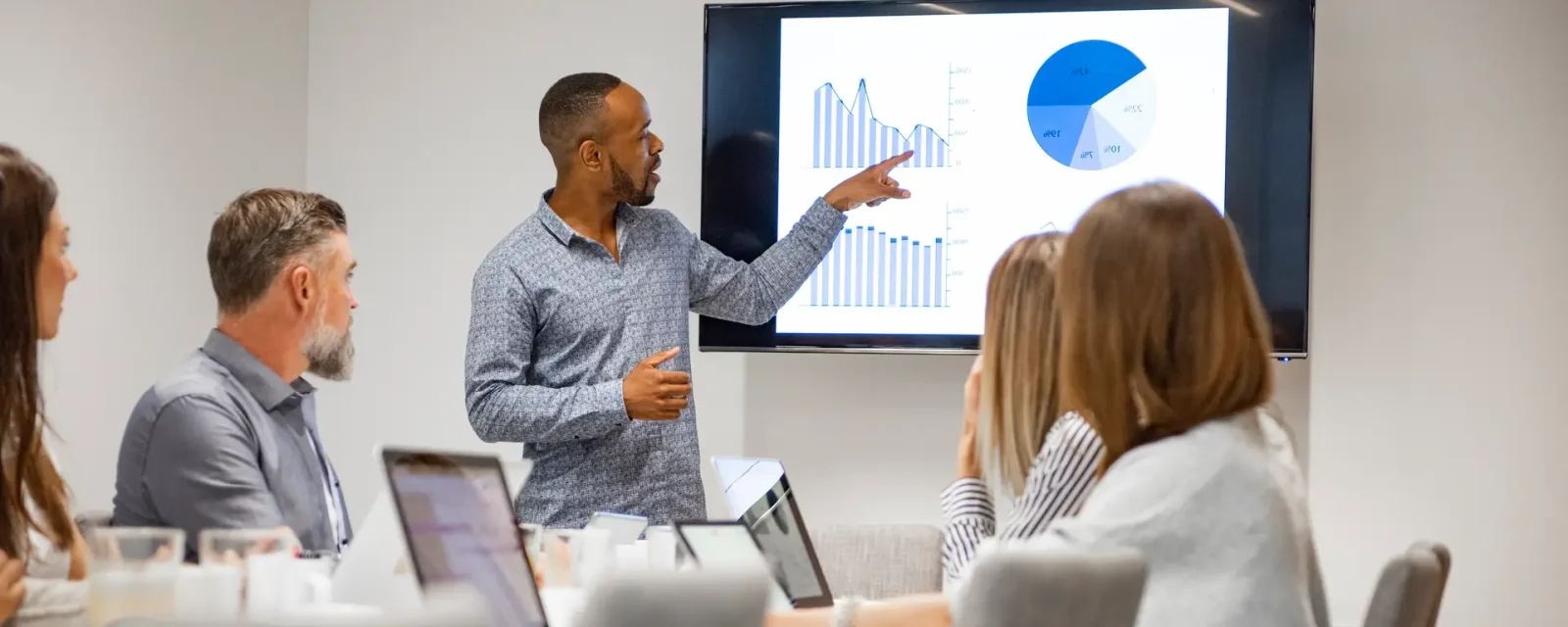 Young businessman giving presentation to his colleagues in modern office.